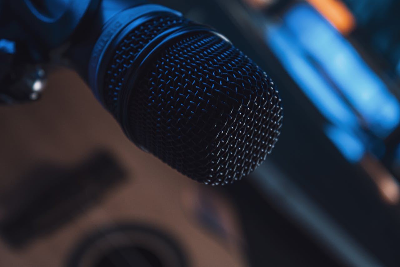Detailed shot of a metallic microphone in a studio setting, showcasing modern audio technology.